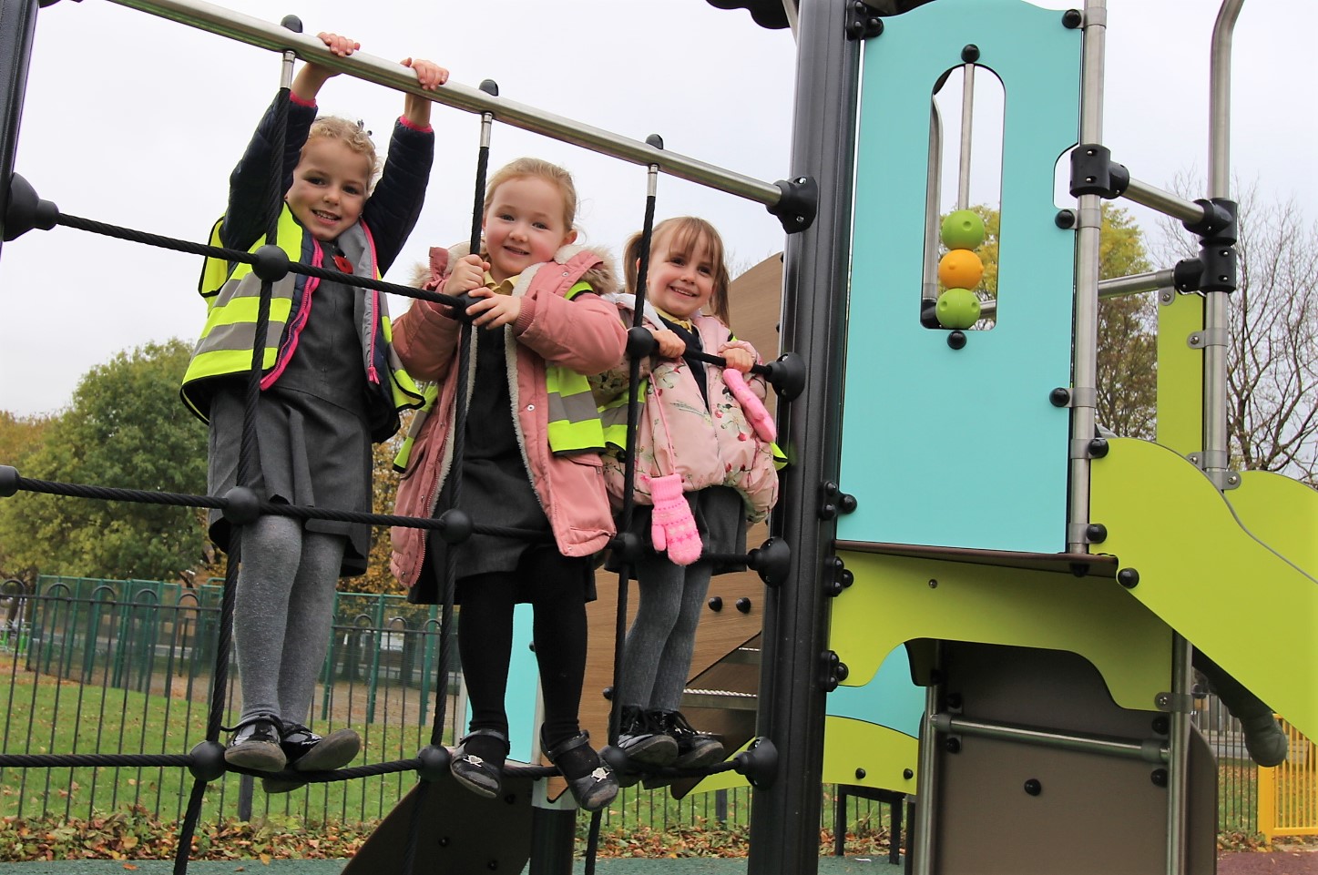 three children playing on a climbing frame